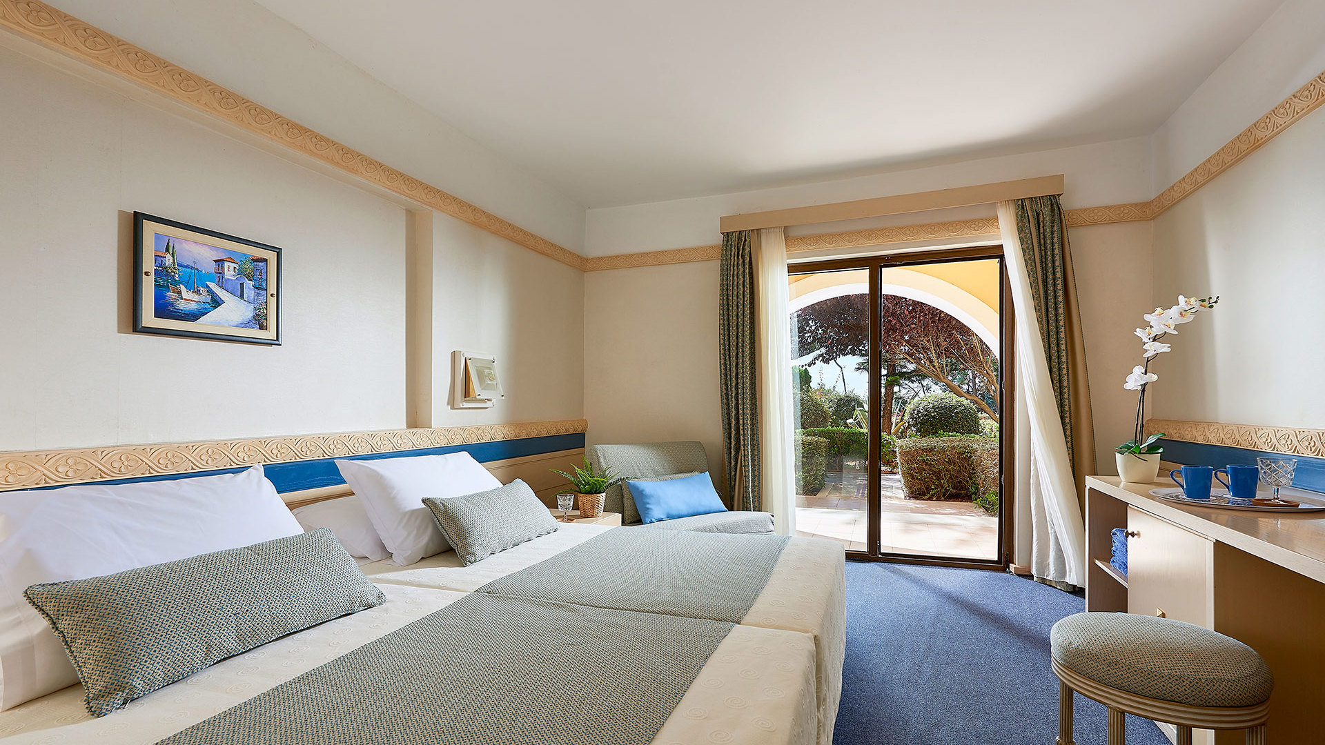 Main Building Double Room Garden View with twin beds and balcony overlooking lush greenery at Aldemar Olympian Village