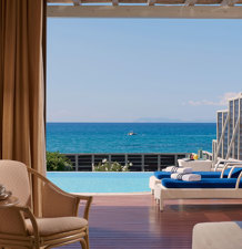 Elegant room opening onto a terrace with sunbeds, pool and sea view at Aldemar Olympian Village in Olympia